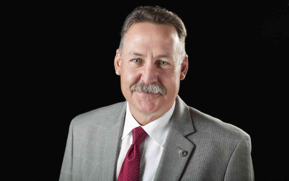 A bust photograph of an executive in a studio environment